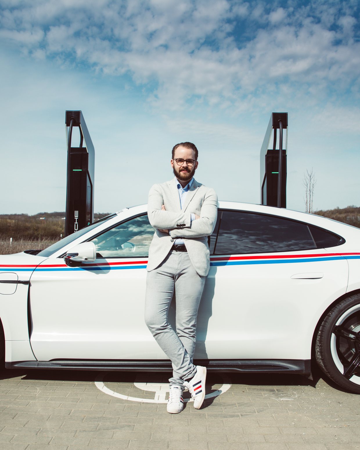 David Wiatr am Porsche Taycan vor 800-Volt-HPC-Ladesäulen